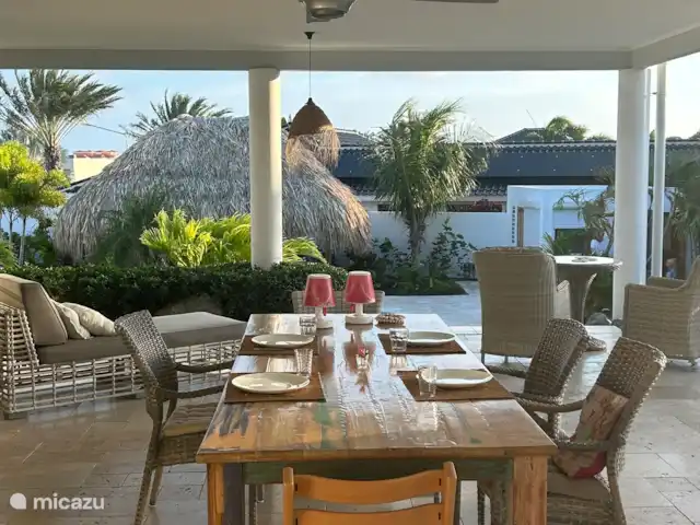 Mangez dehors à une grande table douillette avec vue sur la piscine